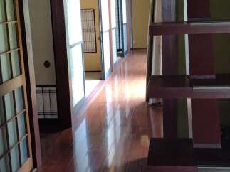 Step into this stunning Japanese-inspired home, featuring a beautiful wooden staircase and a bright, open hallway.