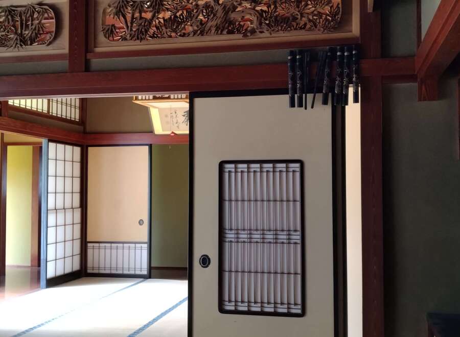 Step into a serene Japanese-style home with intricate wooden carvings and traditional sliding doors.