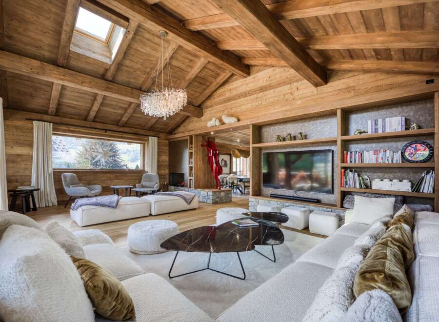 Experience luxury living in this stunning chalet, featuring a warm and inviting interior with exposed wooden beams and a cozy fireplace.