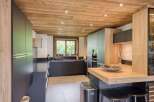 This modern kitchen features a stunning wooden ceiling and sleek, dark cabinetry, creating a warm and inviting atmosphere.