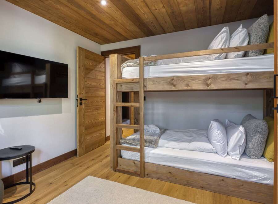 This cozy bedroom features a rustic wooden bunk bed, perfect for accommodating guests or family.