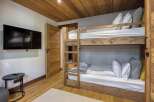 This cozy bedroom features a rustic wooden bunk bed, perfect for accommodating guests or family.
