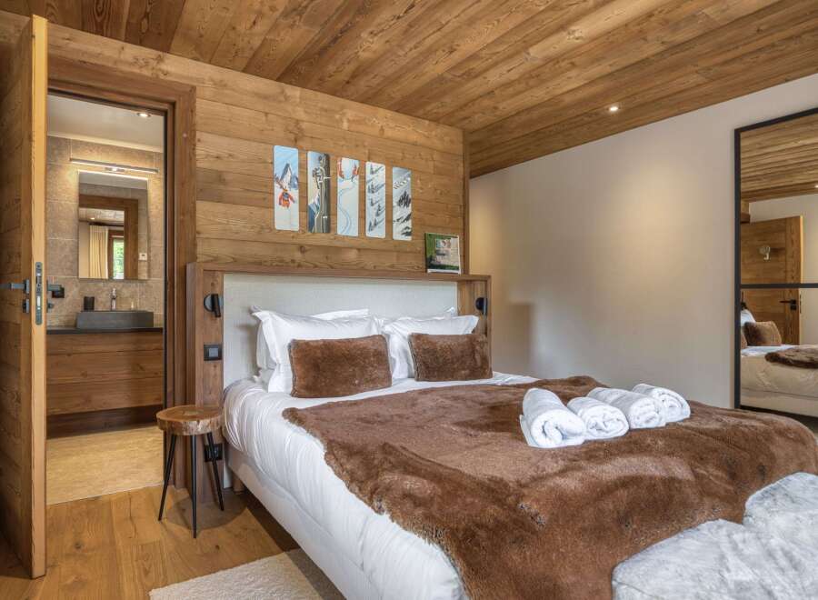 This cozy bedroom features a beautiful wooden ceiling and walls, creating a warm and inviting atmosphere.