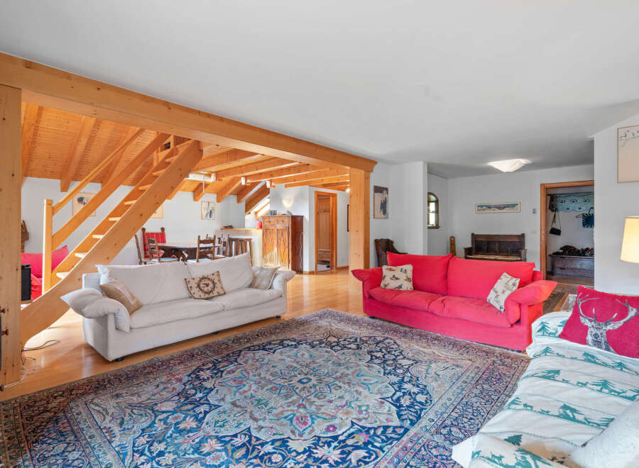 This stunning property boasts a spacious living area with exposed wooden beams, creating a warm and inviting atmosphere.