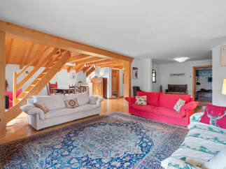 This stunning property boasts a spacious living area with exposed wooden beams, creating a warm and inviting atmosphere.