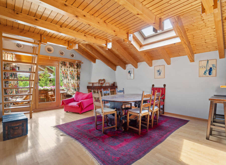 This charming property boasts a unique architectural design with exposed wooden beams and a skylight, creating a warm and inviting atmosphere.