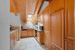 This charming kitchen boasts a warm and inviting atmosphere with its wooden ceiling and cabinetry.