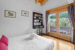 This charming bedroom features a cozy desk area and a stunning view.