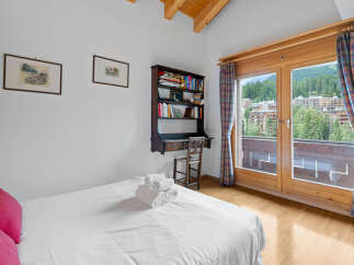 This charming bedroom features a cozy desk area and a stunning view.