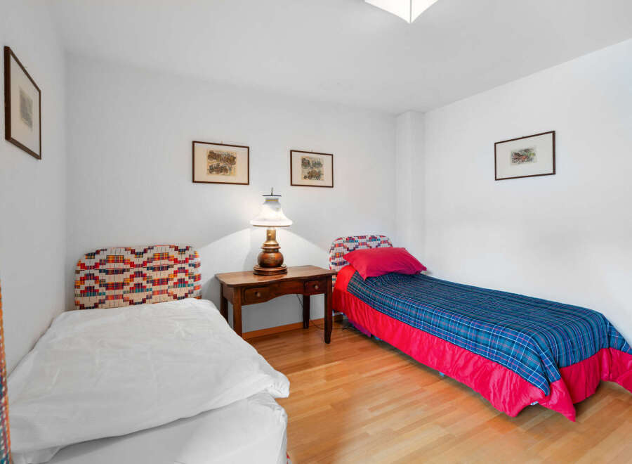This charming bedroom features two single beds, perfect for guests or family members.