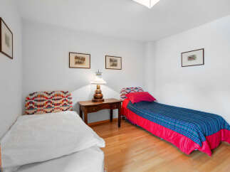 This charming bedroom features two single beds, perfect for guests or family members.
