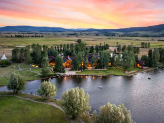 Experience luxury living in this stunning estate, boasting a picturesque lake and lush green surroundings.