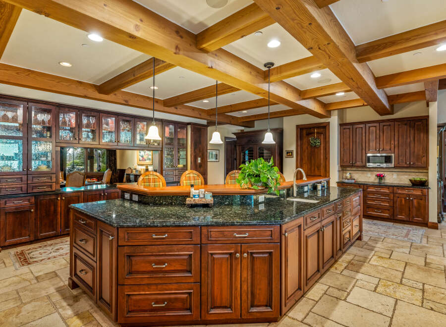 This stunning kitchen boasts a luxurious design with rich wood cabinetry and a spacious island.