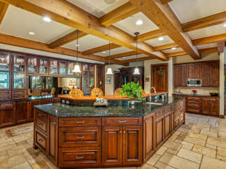 This stunning kitchen boasts a luxurious design with rich wood cabinetry and a spacious island.