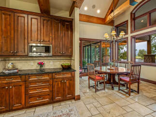 Step into luxury with this stunning kitchen and dining area! Featuring rich wood cabinetry, a sleek granite countertop, and a modern microwave, this space is perfect for both cooking and entertaining.