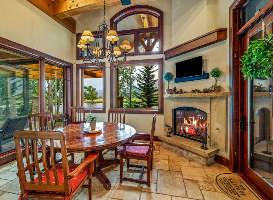 Experience the warmth and charm of this stunning dining room, featuring a cozy fireplace and an inviting round table.