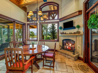 Experience the warmth and charm of this stunning dining room, featuring a cozy fireplace and an inviting round table.