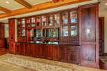 This stunning property boasts a custom-built kitchen with rich, dark wood cabinetry and glass-fronted display cabinets, perfect for showcasing your finest china and glassware.