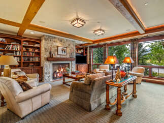 Experience luxury living in this stunning property featuring a cozy living room with a stone fireplace, perfect for relaxing evenings.