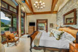 Experience luxury in this stunning bedroom featuring a king-sized bed with an elegant headboard and plush bedding.