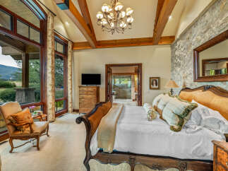 Experience luxury in this stunning bedroom featuring a king-sized bed with an elegant headboard and plush bedding.
