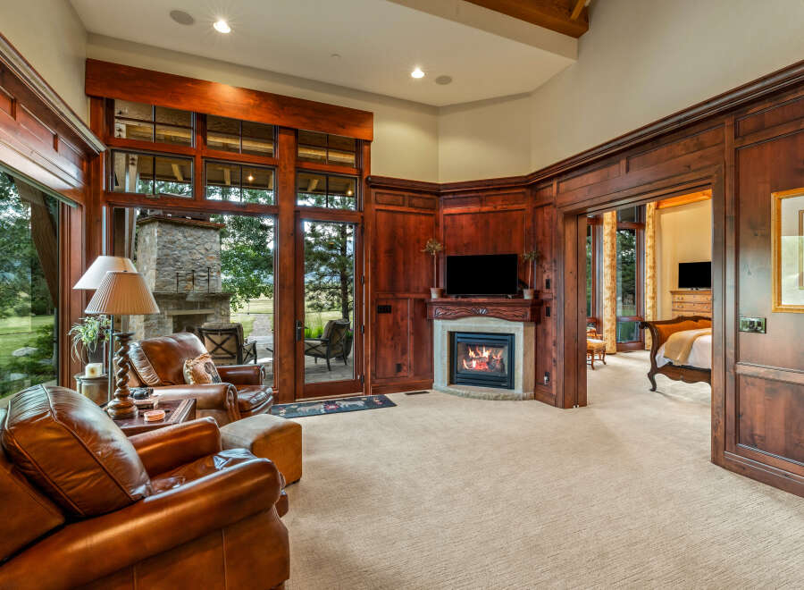 Experience luxury living in this stunning property featuring a cozy fireplace and elegant wood paneling.