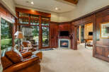 Experience luxury living in this stunning property featuring a cozy fireplace and elegant wood paneling.