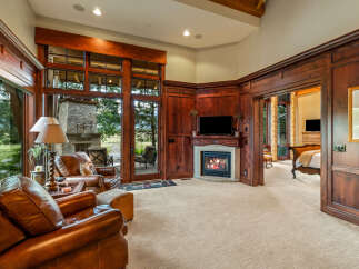 Experience luxury living in this stunning property featuring a cozy fireplace and elegant wood paneling.