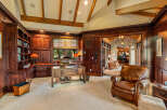 This luxurious home office exudes sophistication with its rich wood paneling and built-in bookshelves.