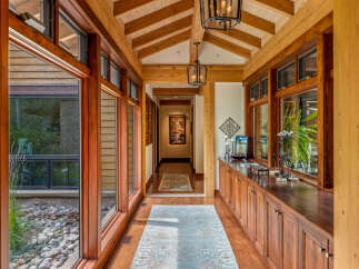 Step into luxury with this stunning hallway, showcasing exquisite wooden beams and elegant lighting fixtures.