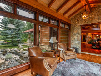 Experience luxury living in this stunning property, featuring a cozy seating area with comfortable leather armchairs.