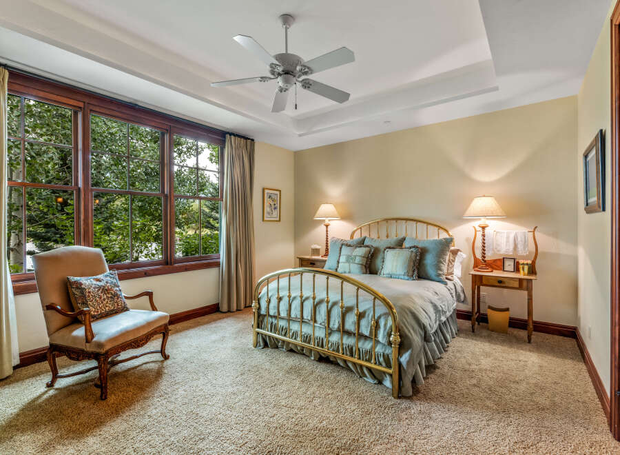 Step into this elegant bedroom, featuring a luxurious brass bed frame and plush bedding.