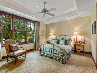 Step into this elegant bedroom, featuring a luxurious brass bed frame and plush bedding.