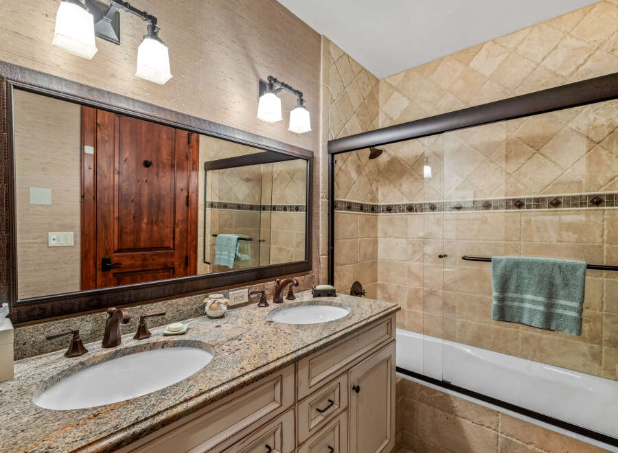 This luxurious bathroom features a double vanity with granite countertops, offering ample space and elegance.