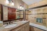 This luxurious bathroom features a double vanity with granite countertops, offering ample space and elegance.