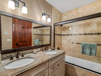 This luxurious bathroom features a double vanity with granite countertops, offering ample space and elegance.