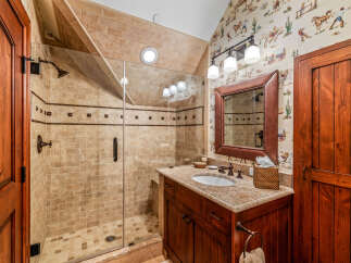 This stunning bathroom features a luxurious walk-in shower with elegant tile work and a frameless glass door.