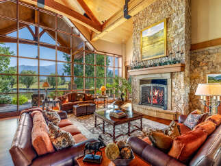 Experience luxury living in this stunning property featuring a grand living room with expansive windows offering breathtaking views.