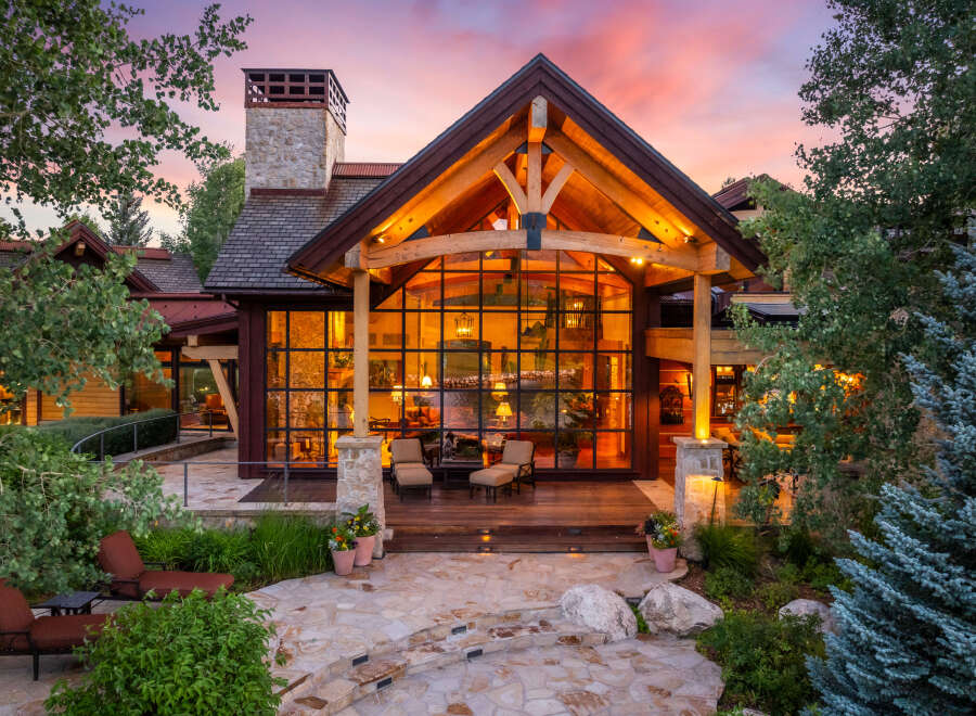 Experience luxury living in this stunning property, featuring a grand entrance with a stone pathway and lush landscaping.