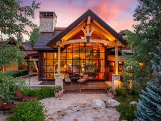 Experience luxury living in this stunning property, featuring a grand entrance with a stone pathway and lush landscaping.