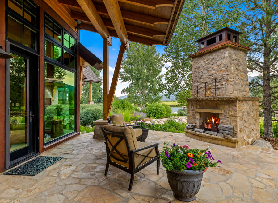 Experience luxury living in this stunning property featuring an outdoor fireplace, perfect for cozy evenings.