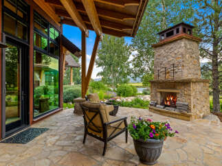 Experience luxury living in this stunning property featuring an outdoor fireplace, perfect for cozy evenings.