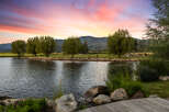 Experience tranquility at this stunning property, featuring a serene lake and lush greenery.