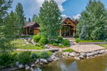 This stunning property showcases a luxurious home nestled amidst lush landscaping and a serene pond.