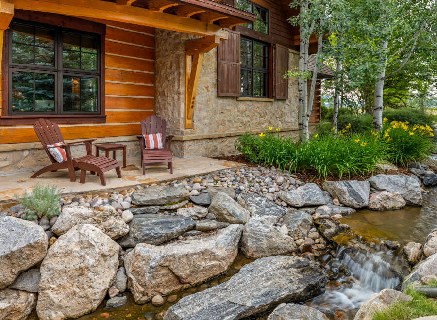 This stunning property boasts a beautiful exterior with a charming wooden facade and stone accents.