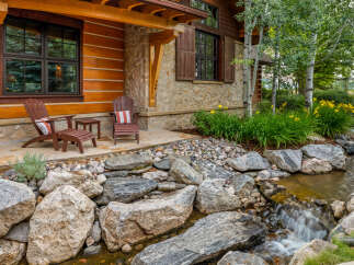 This stunning property boasts a beautiful exterior with a charming wooden facade and stone accents.