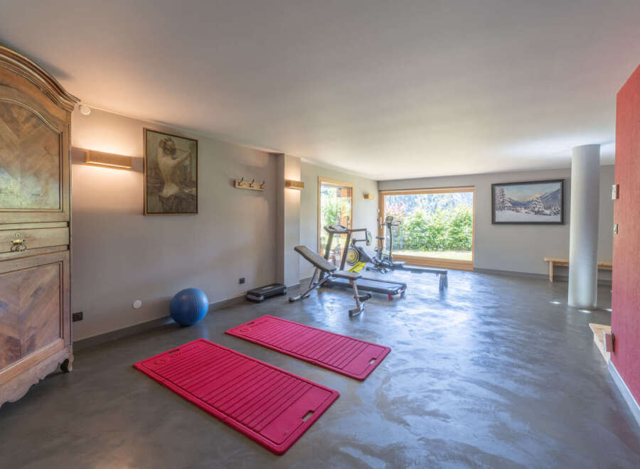 This spacious home gym offers a serene workout environment with ample natural light and modern equipment.