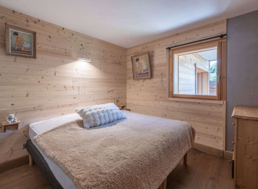 This cozy bedroom features beautiful wooden paneling, creating a warm and inviting atmosphere.