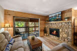 Cozy up in this charming living room featuring a stunning stone fireplace and a large flat-screen TV.