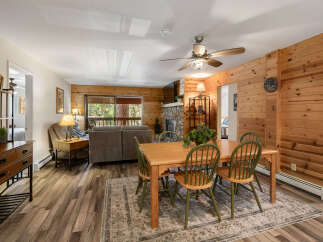 Step into this inviting living space, featuring a cozy fireplace and warm wood paneling that creates a rustic ambiance.